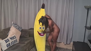 Naked in the living room making love and humping a big inflated banana, closeups